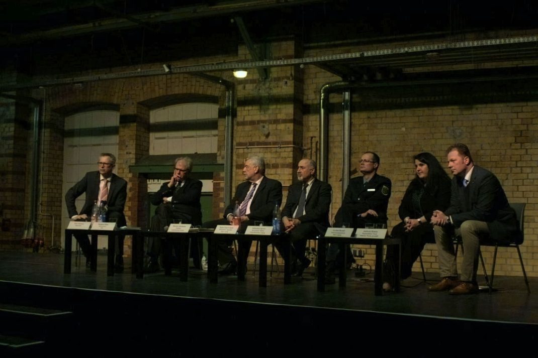 Podium. vlnr.: Peter Stawowy (Moderator), Reinhard Boos (Referatsleiter sächs. Innenministerium), Dietrich Gökelmann (Präsident Landesdirektion Sachsen), Stojan Gugutschkow (Referatsleiter Migration Stadt Leipzig), Sebastian Spreer (Revierleiter Südost Polizeidirektion Leipzig), Gerlind Berndt (Niederlassungsleiterin SIB I Leipzig), Andreas Konen (Regionalleiter Nord Malteser Werke gGmbH)