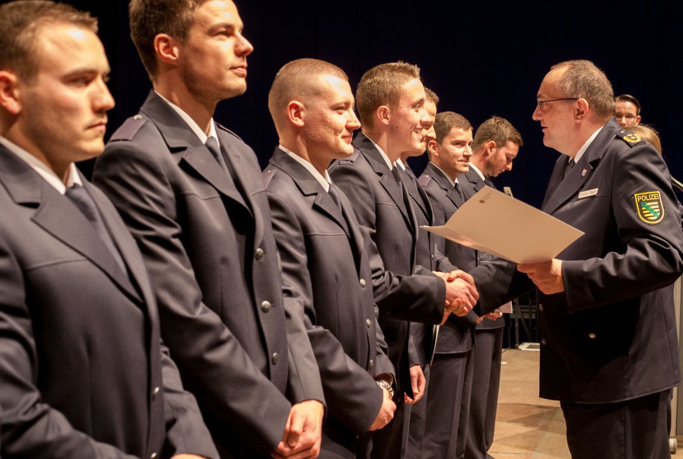 Der Görlitzer Polizeipräsident Conny Stiehl überreicht seinen künftigen Kollegen ihre Ernennungsurkunden. Foto: Bereitschaftspolizei Sachsen