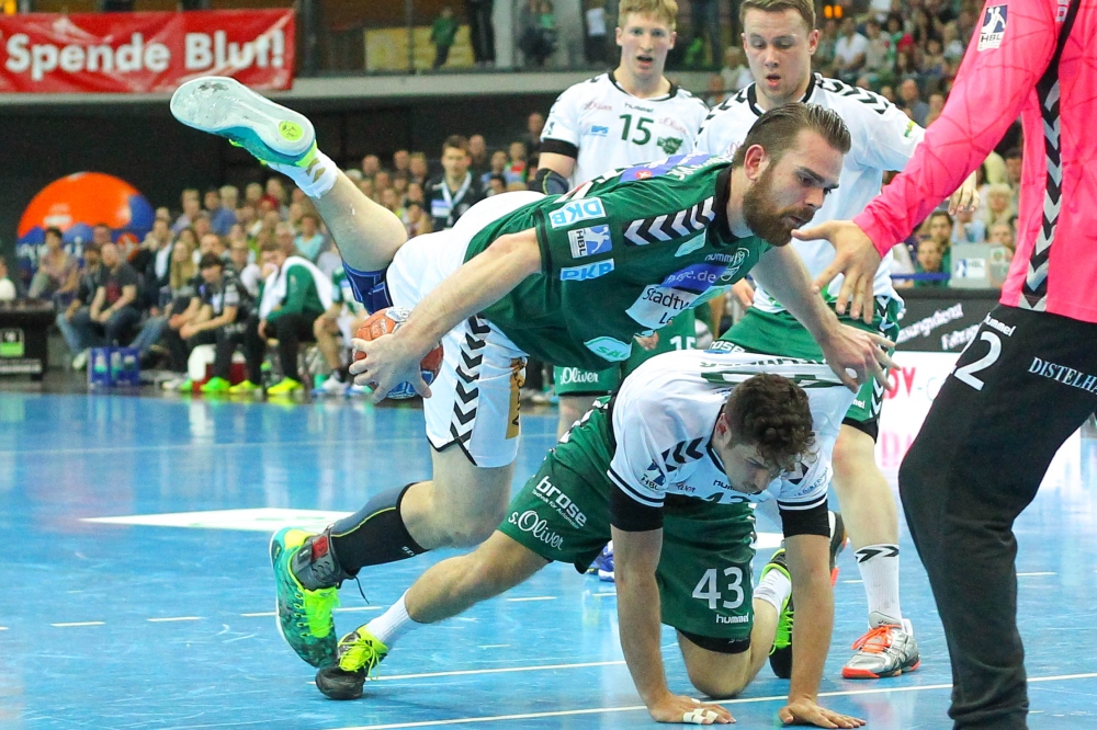 Körperbeherrschung: Alen Milosevic (SC DHfK) segelt über den am Boden liegenden Benedikt Brielmeier (Rimpar) und bringt den Ball trotzdem auf's Tor. Foto: Jan Kaefer