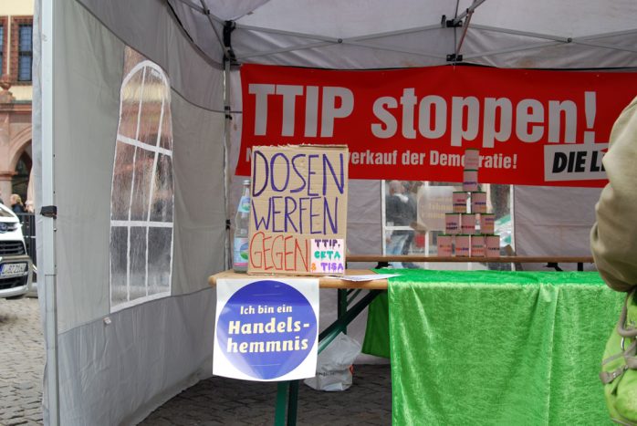Dosen werfen gegen TTIP am Stand der Linkspartei und der Mensch als Handelshemmnis