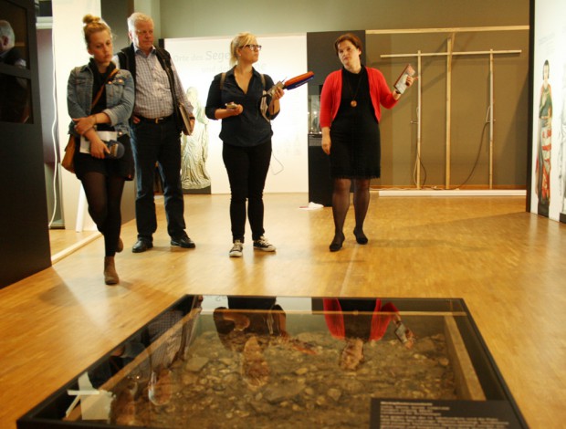 Ein Stück vom alten Marktpflaster aus dem 14. Jahrhundert. Rechts: Kuratorin Dr. Maike Günther. Foto: Ralf Julke