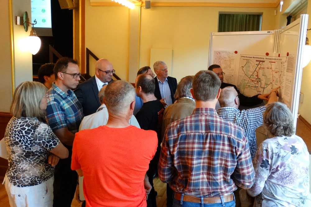 Eine der vier Gruppen, die an den Info-Wänden mit den ausgehängten Plänen mit den Verkehrsplanern des MDV ins Gespräch kommen. Foto: Patrick Kulow.