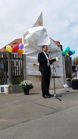 Pfarrer Christoph Maier vor der verhüllten Stele. Foto: Marko Hofmann