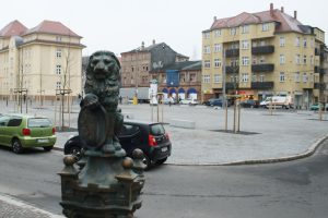 Der Löwe von der Pumpe am Huygensplatz und im Hintergrund der "Goldene Löwe". Foto: Ralf Julke