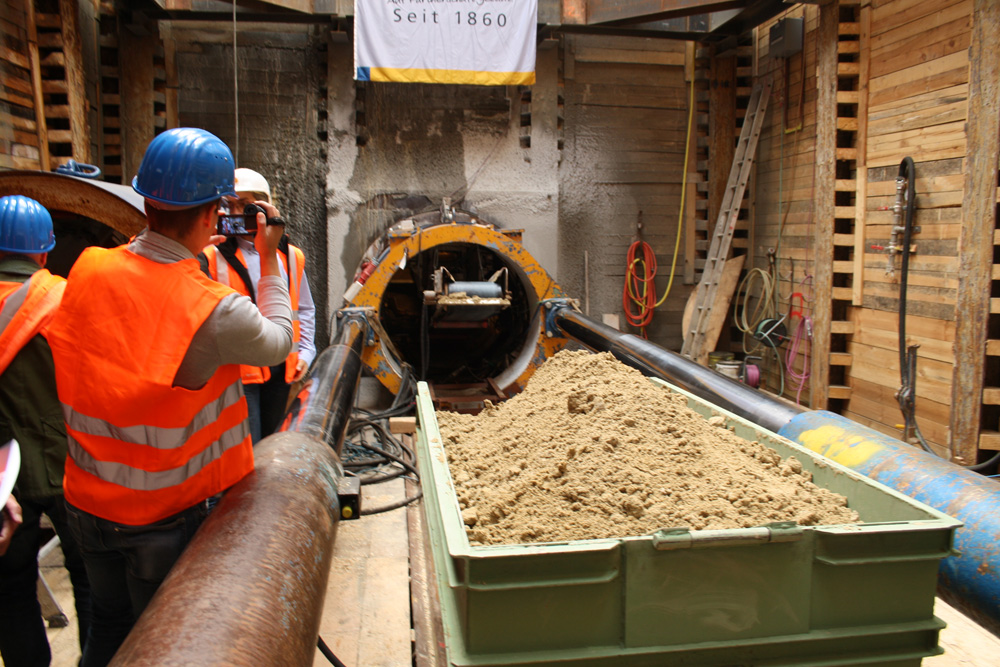 Blick über die Lore mit dem ausgefrästen Bodenmaterial in die Röhre der Vortriebsmaschine mit dem Förderband. Foto: Ralf Julke