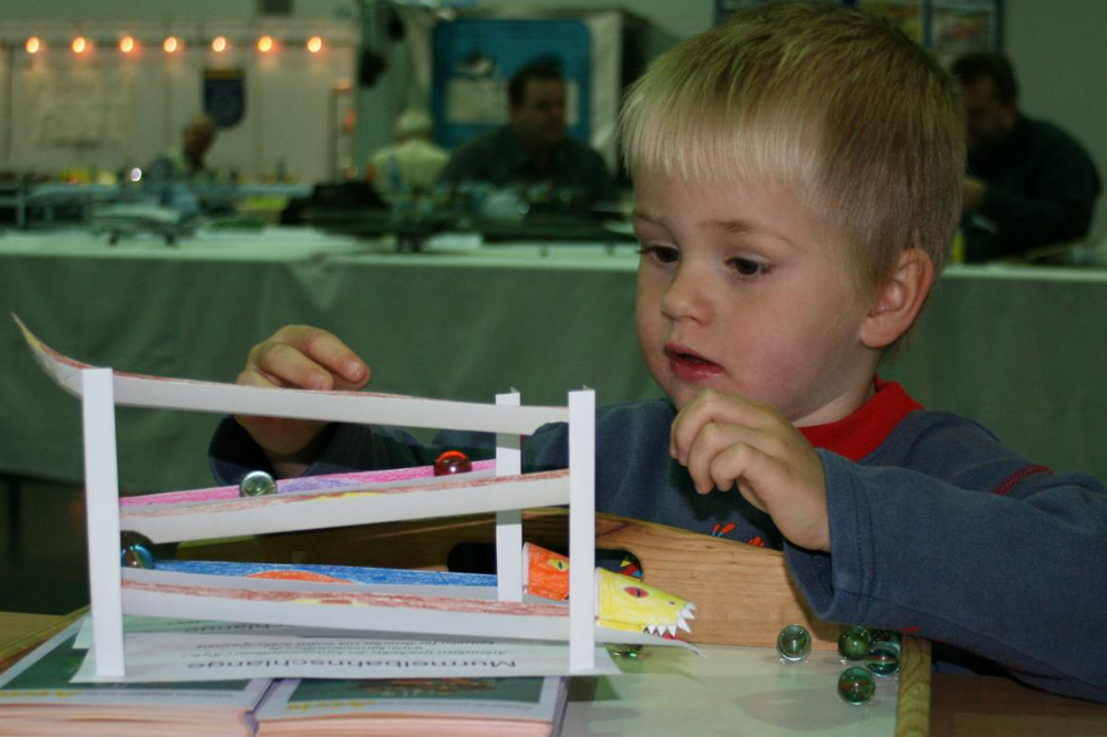 Freudige Kinderaugen probieren eine Murmelbahn aus. Foto: Heiko Schinke