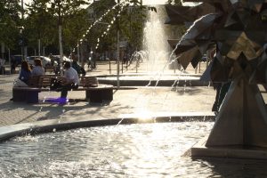 Rettung an heißen Tagen: ein Plätzchen am Brunnen auf dem Richard-Wagner-Platz. Foto: Ralf Julke