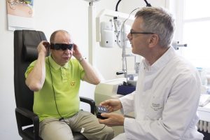 Bernd Burkhardt beim ersten Anschalten der neuen Retinaprothese. Foto: Stefan Straube/UKL