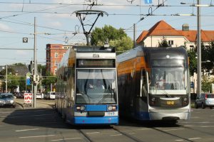 Zwei Straßenbahnen und ein siegesgewisser Straßenbahnfahrer am Augustusplatz in Leipzig. Foto: Ralf Julke