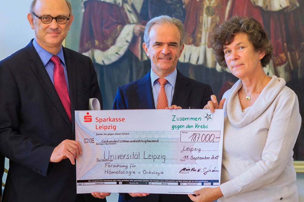 Alexander Prinz von Sachsen (Mitte) übergibt einen Spendenscheck an Rektorin Prof. Dr. Beate Schücking und Prof. Dr. Dietger Niederwieser. Foto: Uni Leipzig