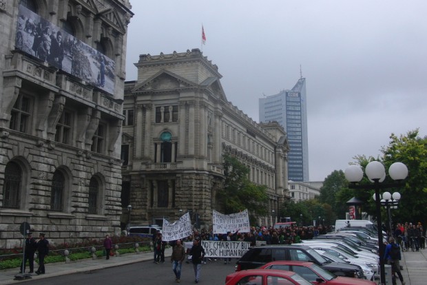 Der Demozug passiert das Fotobanner am Rathaus zum Thema Flucht und Vertreibung. Foto: René Loch