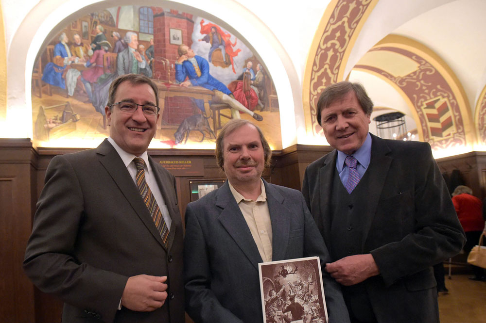 Bernhard Rothenberger, Pächter Auerbachs Keller, Künstler Volker Pohlenz und Bernd Weinkauf, Haushistoriker des Auerbach Keller, (von links) vor dem neuen Gemälde "Goethes Faust-Inspiration", das ab sofort im Großen Keller hängt. Foto: Christian Modla