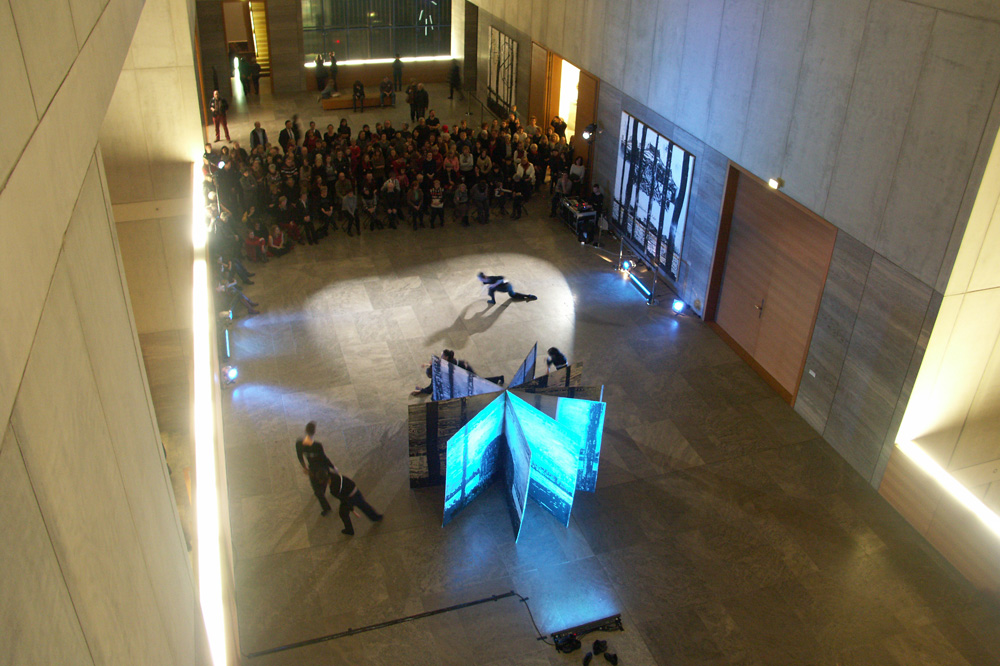 Anselm Kiefers Buch-Skulptur mit dem Titel „Der Rhein“ steht im Zentrum der Spielfläche, drumherum fließen die Tänzer. Foto: Karsten Pietsch