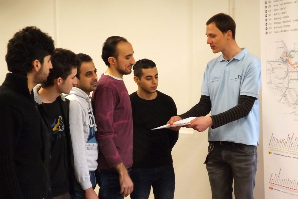 MDV-Mitarbeiter Christian Böttcher (rechts im Bild) gibt Ahmad Zino aus Syrien (4. von links) und den weiteren Kursteilnehmern Tipps zu den Angeboten des MDV. Foto: MDV