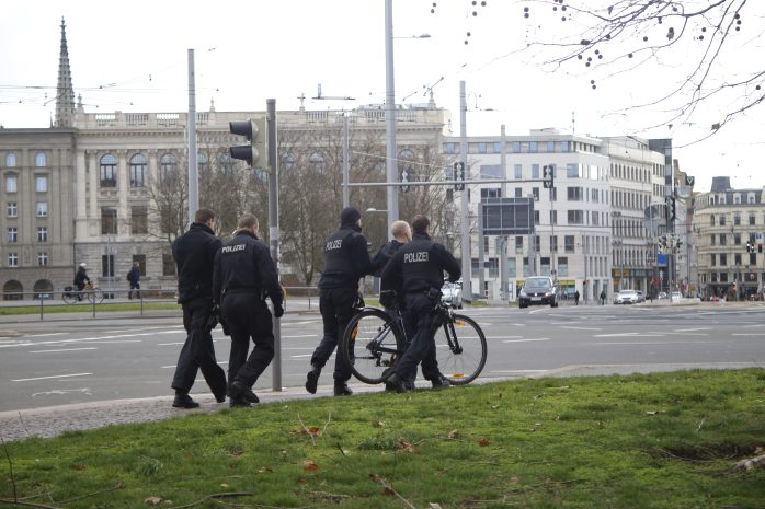Polizisten führen einen Mann ab, der einen Platzverweis nicht befolgte. Foto: Alexander Böhm