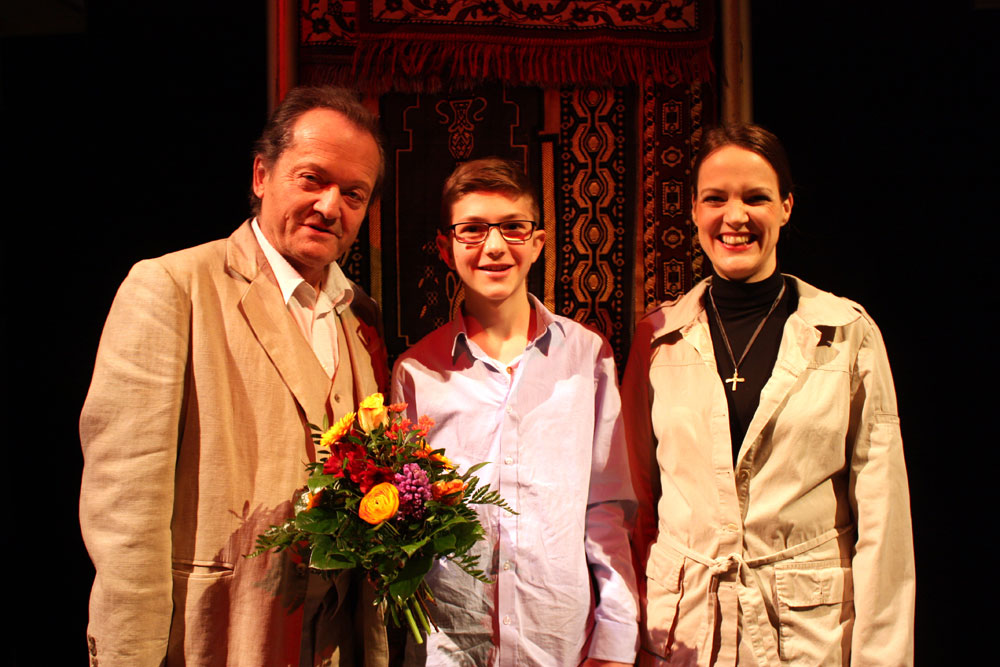 v.l.: Reinhart Reimann (Nathan, seit 2005 dabei), Max Gläser (20 000. Besucher), Katja Bramm (Daja, seit dieser Spielzeit in der Rolle). Aufgenommen im Bühnenbild von „Nathan der Weise“. Foto: TdJW