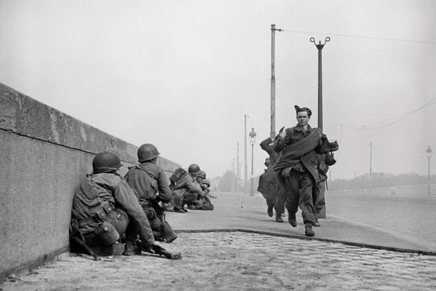 Kapitulierende deutsche Soldaten überqueren die Zeppelinbrücke, während US-Soldaten gedeckt vorrücken. 18. April 1945. Foto: Robert Capa, Copyright International Center of Photography/Magnum Photos