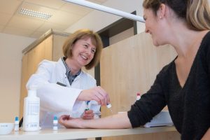 Prof. Regina Treudler, Geschäftsführende ärztliche Leiterin des LICA, nimmt bei einer Patientin einen Allergietest vor. Foto: Stefan Straube / UKL