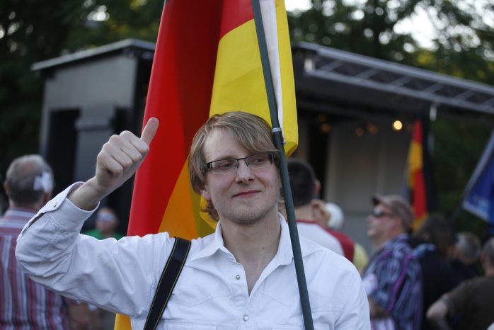 19:45 Uhr: Ein fotogener LEGIDA-Teilnehmer mit Facebookdaumen und Deutschlandfahne. Foto: L-IZ.de
