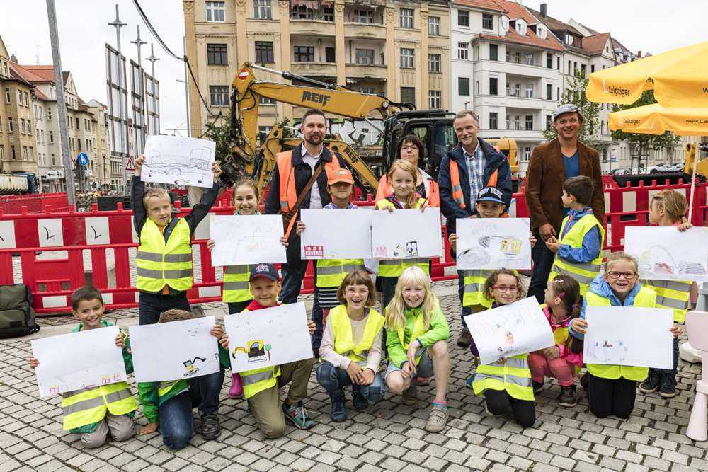 v.l. Daniel Brucker (Projektleiter der Leipziger Verkehrsbetriebe), Kirsten Völker (Projektsteuerin der Bau+Service Leipzig GmbH im Auftrag der Leipziger Wasserwerke), Christoph Bock (Abteilungsleiter Straßenbau und -unterhaltung im Verkehrs- und Tiefbauamt der Stadt Leipzig), Roland Löbel (Magistralenmanagement Georg-Schumann-Straße und Ferienkinder der 39. Grundschule). Foto: Leipziger Gruppe