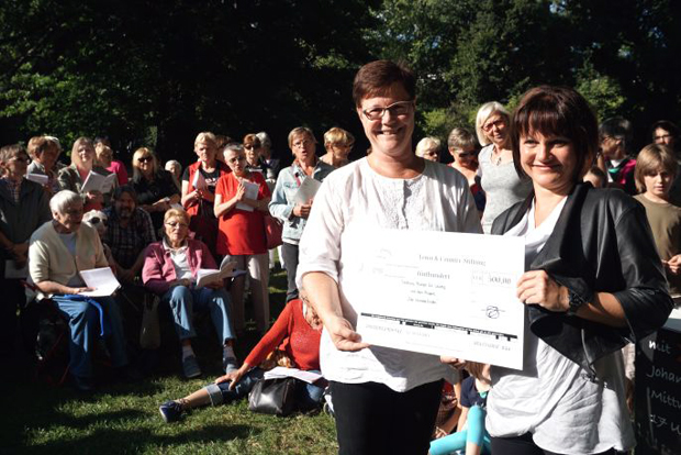 Manuela Bellmann (r.), Botschafterin der Town & Country Stiftung und Prokuristin der Bellmann Immobilien GmbH & Co. KG bei der Spendenübergabe mit Angelika Kell, geschäftsführender Stiftungsvorstand der Stiftung Bürger für Leipzig. Diese fand im Rahmen des „Bürgersingens im Johannapark“ statt. Foto: Creative Commons