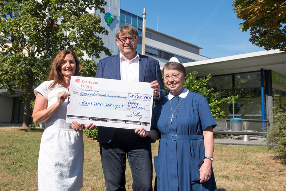 Die Diakonisse Maria Wermuth (r.) und Diako-Geschäftsführer Christoph Möllering überreichen den Spendenscheck an Michaela Bax, stellvertretende Vorstandsvorsitzende des Haus Leben e. V.: Foto: DKL/Kay Zimmermann