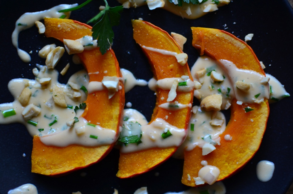 Kürbisspalten mit Kräuter-Käse-Sauce. Foto: Maike Klose