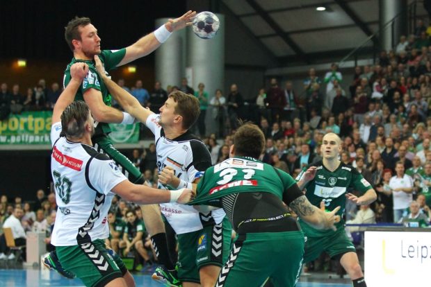 Andreas Rojewski (DHfK) versucht unter Bedrängins, seinen Kollegen Benjamin Meschke am Kreis zu finden. Foto: Jan Kaefer