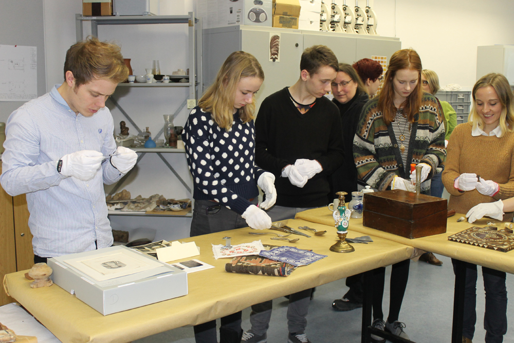 Anfassen ausnahmsweise erlaubt – unter Anleitung von Dozenten kann man am Schnupperwochenende üben, wie ausgewählte historische Objekte richtig gehandhabt und bestimmt werden. Foto: HTWK Leipzig/Museologie