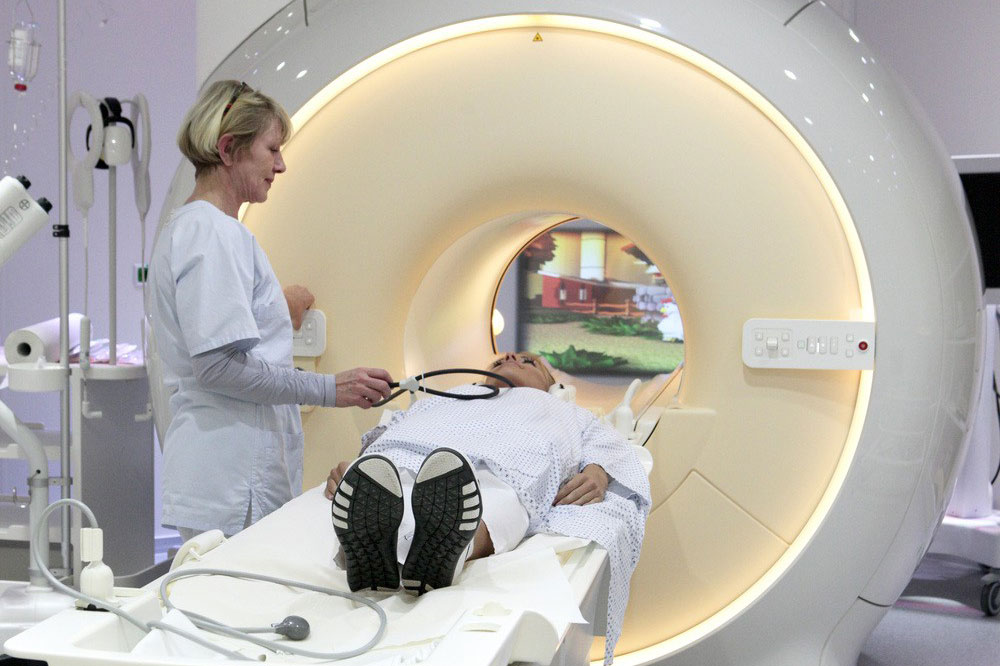 MTRA Cathrin Vörkel demonstriert die Arbeit am neuen 3-Tesla-MRT. Es löst das bisherige 1,5-Tesla-Gerät ab. Bei der im Foto gezeigten Situation handelt es sich nicht um eine tatsächliche Behandlung. Foto: Ines Christ / UKL