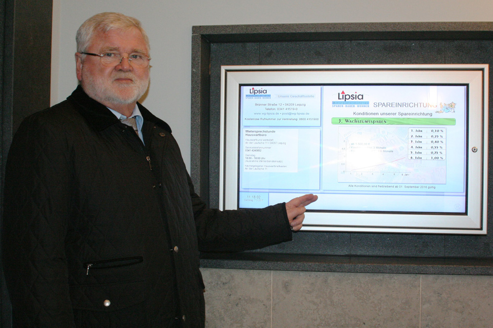 Lipsia-Vorstand Wilhelm Grewatsch vor einer der neuen elektronischen Haustafeln. Foto: „Lipsia“ eG