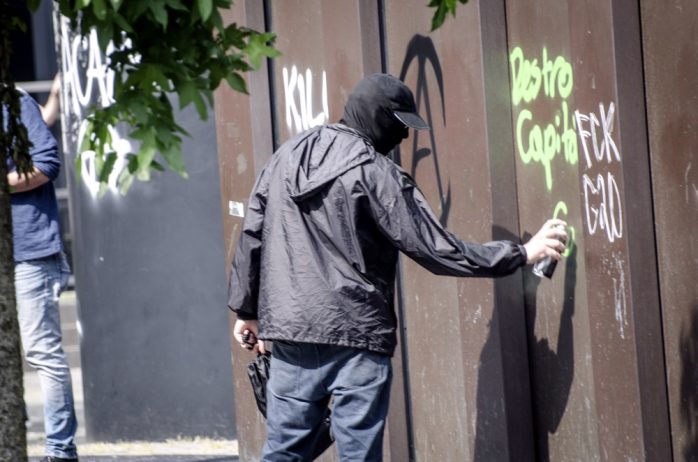Ein vermummter Demonstrant sprüht bei den Aktionen gegen G20 am Nachmittag des 07.07. etwas an ein Gebäude. Foto: Tim Wagner