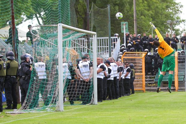 Nach dem Platzverweis fuer Chemie-Torwart Doelz, stand Verteidiger Manuel Wajer zwischen den Pfosten - beobachtet vom aufmarschierten Sicherheitspersonal. Foto: Jan Kaefer