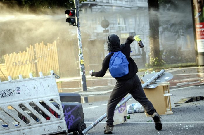 Demonstrant wirft eine Flasche auf einen Wasserwerfer am neuen Pferdemarkt. Foto: Tim Wagner