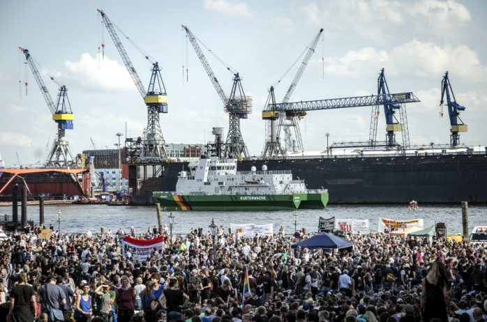 Auftakt der "Welcome to Hell" Demonstration gegen den G20 Gipfel auf dem Fischmarkt. Im Hintergrund der Hamburger Hafen. Foto: Tim Wagner