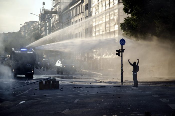 Demonstrant zeigt Wasserwerfer den Mittelfinger am neuen Pferdemarkt. Foto: Tim Wagner