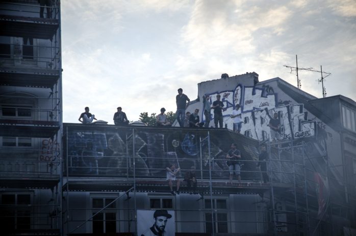 Demonstrierende am Eingang zum Schulterblatt vom neuen Pferdemarkt aus auf einem Gerüst und Hausdach. Foto: Tim Wagner