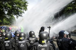 Die Polizei setzt Wasserwerfer gegen Demonstranten ein, welche die Schröderstiftstraße in Hamburg blockieren. Sie gehören zum grünen und blauen Finger der Aktion: "Colour the red zone" im Protest gegen den G20 Gipfel. Foto: Tim Wagner
