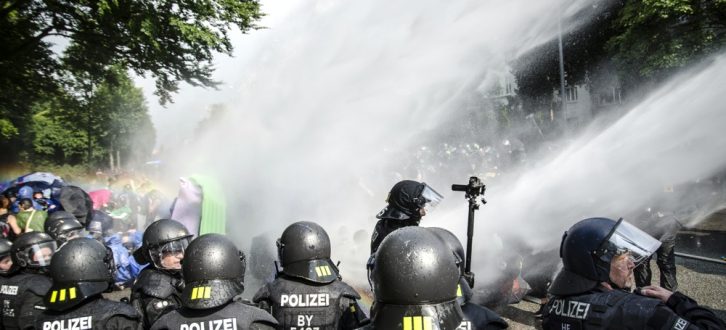 Die Polizei setzt Wasserwerfer gegen Demonstranten ein, welche die Schröderstiftstraße in Hamburg blockieren. Sie gehören zum grünen und blauen Finger der Aktion: "Colour the red zone" im Protest gegen den G20 Gipfel. Foto: Tim Wagner