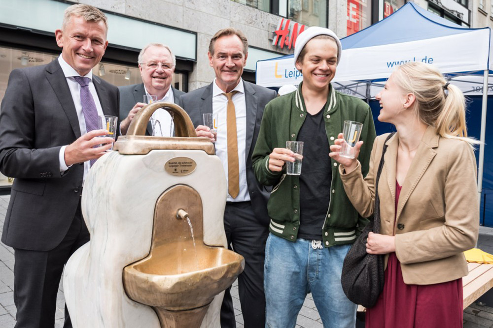 Der Trinkbrunnen in der Leipziger Petersstraße ist seit heute in Betrieb: Dr. Norbert Menke (LVV), Michael M. Theis (Leipziger Wasserwerke), Oberbürgermeister Burkhard Jung sowie Rudy Brabec und Pauline Haupt vom Leipziger Jugendparlament (v.l.n.r.) nehmen die ersten Schlucke. Foto: Leipziger Gruppe