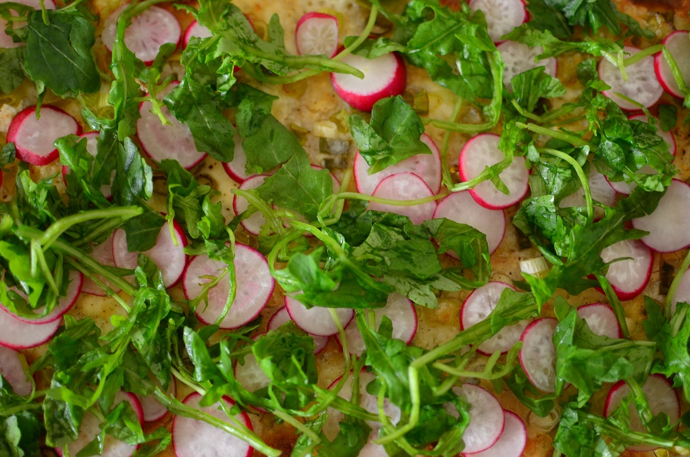 Flammkuchen mit Radieschen und Rucola. Foto: Maike Klose