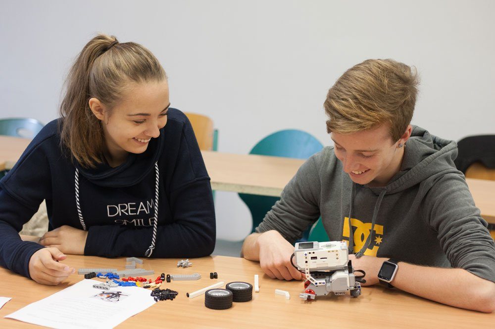 Lego-Roboter „Roberta“ – hier noch in Einzelteilen – wartet darauf, dass die Gymnasiasten Kassandra Nerlich und Lorenz Gottschalk sie zusammenbauen und programmieren. Das Bild entstand während der Ferienhochschule im Herbst. Foto: Kristina Denhof/ HTWK Leipzig