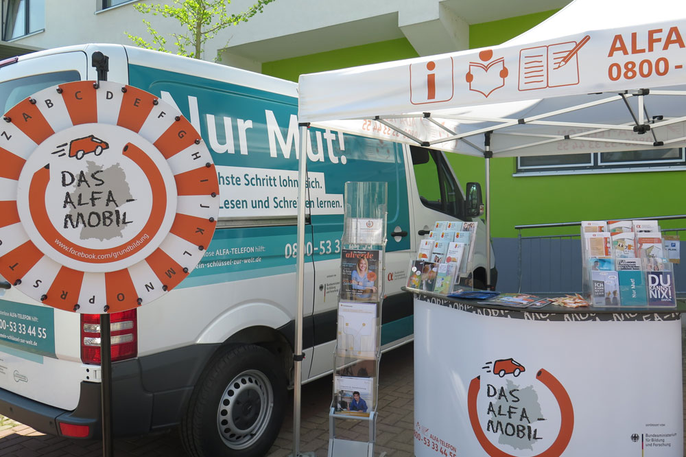 Aufsuchende Beratung: Am ALFA-Mobil-Stand informieren Mitarbeiter interessierte Bürger und Menschen mit Lese- und Schreibschwierigkeiten. Foto: Projekt ALFA-Mobil