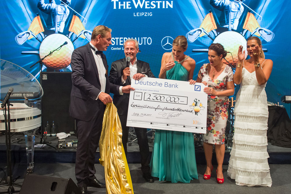 Exakt um 01:28 Uhr präsentierte Initiator und Veranstalter Steffen Göpel (2.v.l./Instone Real Estate) gemeinsam mit Schirmherr und Oberbürgermeister Burkhard Jung (l.), Moderatorin Peggy Schmidt, Katarina Witt und Franziska van Almsick den Spendenscheck des 10. GRK Golf Charity Masters Leipzig über 2,5 Millionen Euro. Foto: Christian Modla/Westend Communication.