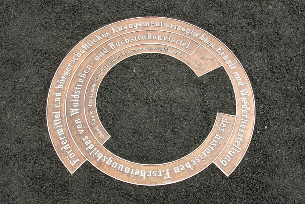 Die am Waldplatz eingelassene Bronzeplatte zur Würdigung der Städtebauförderung im Waldstraßen- und Bachstraßenviertel. Foto: Stadt Leipzig