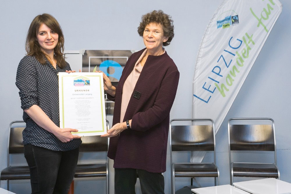 Kristina Klecko von Fairtrade Deutschland übergibt die Rezertifizierungsurkunde an Rektorin Beate Schücking (rechts). Foto: Swen Reichhold