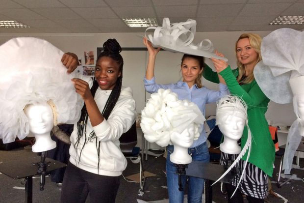 Die Vitruvius-Modestudentinnen Obakeng Döhler und Tessa Gentsch sowie Standortleiterin Susanne Zaspel (v.l.) geben erste Einblicke in die Hutwerkstätten der Modehochschule. Foto: Scheibenholz