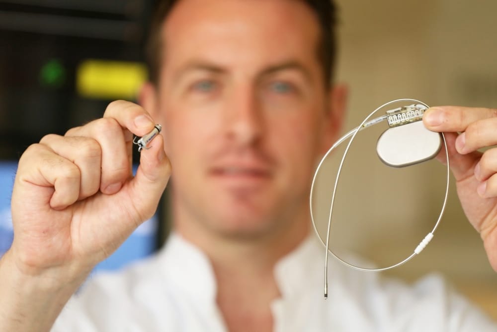 Neu und alt im Größenvergleich: Oberarzt Dr. Daniel Jurisch mit dem kleinen kapselartigen Herzschrittmacher, rechts dazu ein bisheriges Modell mit Kabel und Sonde. Foto: Ines Christ/UKL