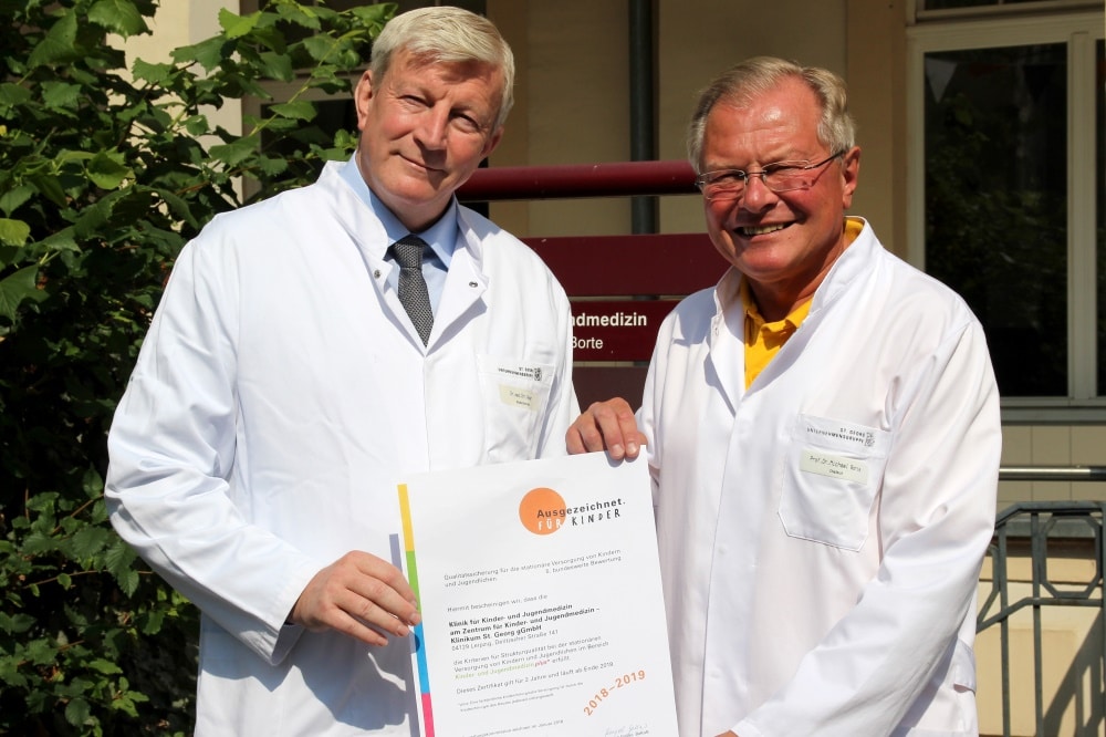 Dr. Christian Geyer (links), Leiter des Zentrums für Kinder und Jugendmedizin und Chefarzt der Klinik für Kinderchirurgie, nimmt gemeinsam mit Prof. Dr. Michael Borte, Chefarzt der Klinik für Kinder- und Jugendmedizin, stolz das Zertifikat entgegen. Foto: Klinikum St. Georg
