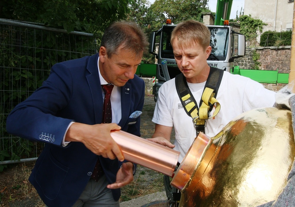 Landrat Kai Emanuel (links) mit Thomas Müller (Metalldrückerei Wurzen) bei der Platzierung der Dokumentenhülsen in der Turmkugel. Foto: Landratsamt